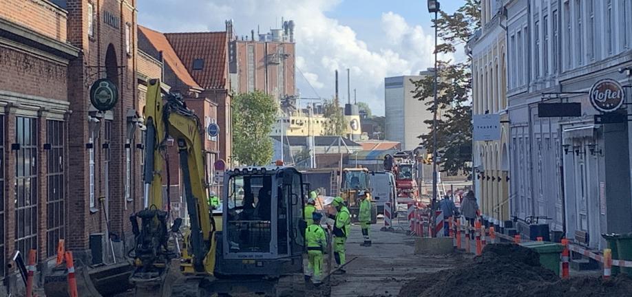 Gravkø og arbejdsmænd i gule dragter der graver gade mod Svendborg Havn op 